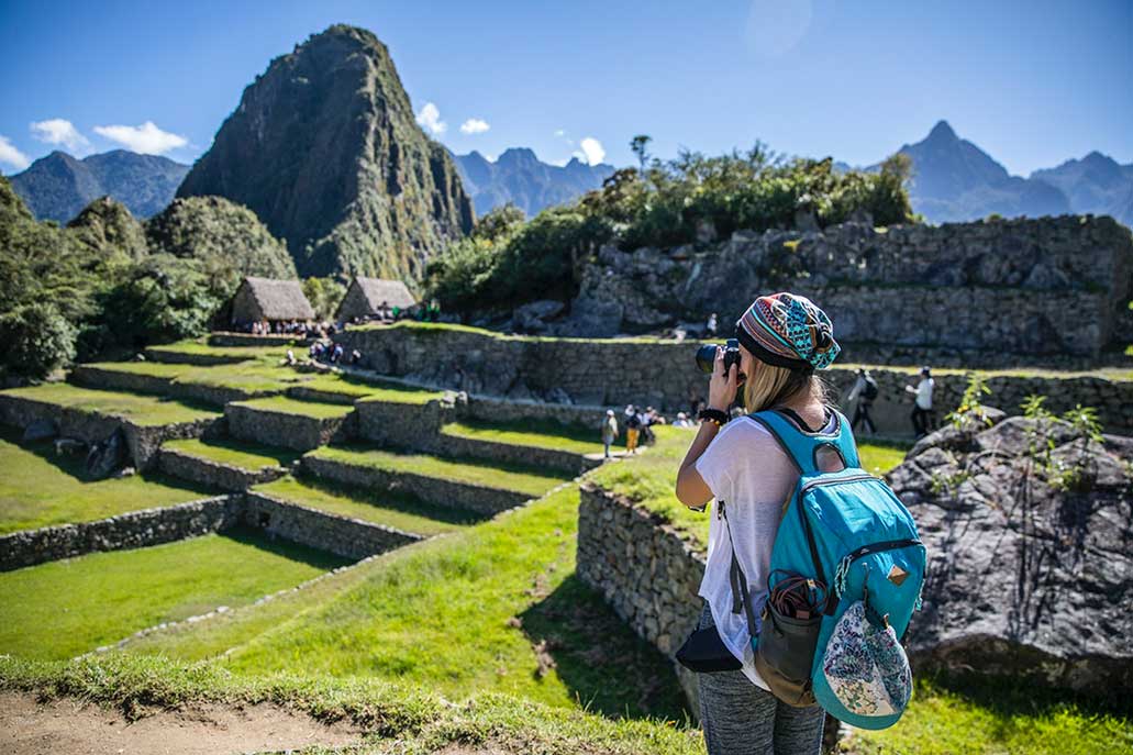 Turista fotografiando las ruinas de Machu Picchu