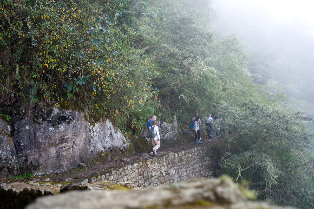 Turistas dirigiéndose al Puente Inca en un día nublado